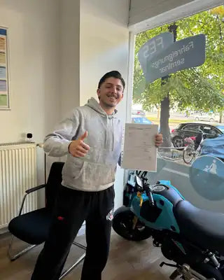 Fahrschüler nach bestandener Prüfung mit Fahrlehrer
