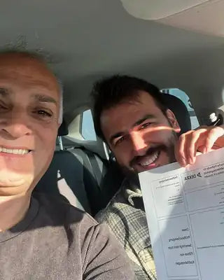 Fahrschüler nach bestandener Prüfung im Fahrschulwagen