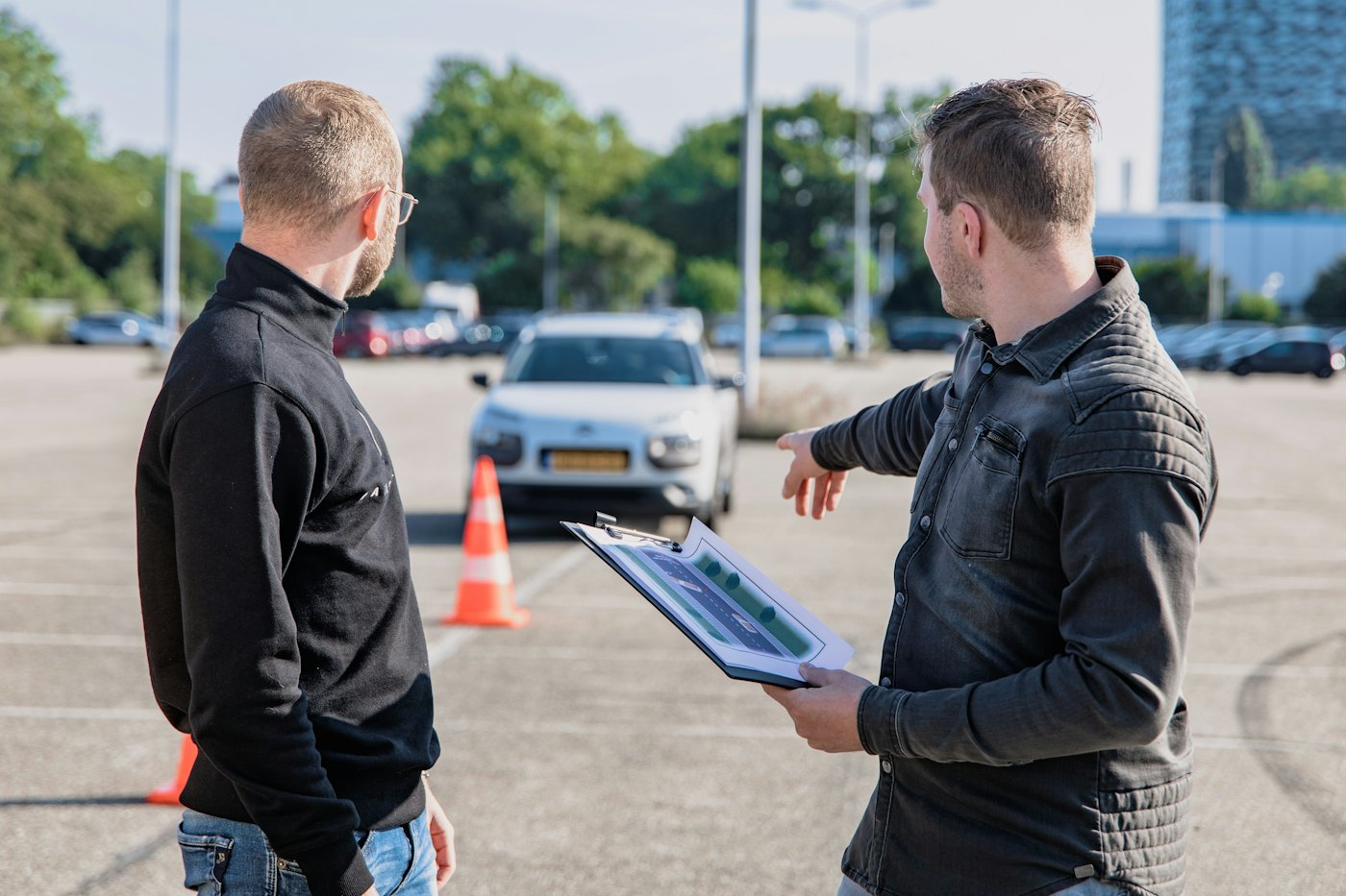 Fahrlehrer erklärt am Fahrschulwagen
